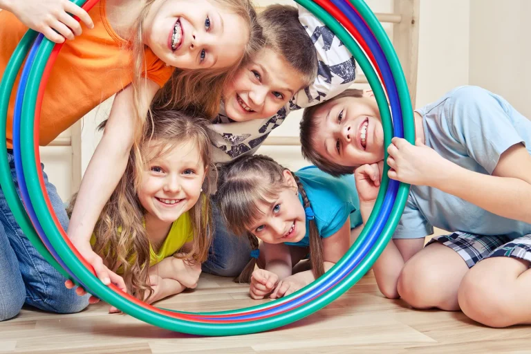 Groupe d’enfants souriants participant à une activité multisport avec cerceaux à Toulouse