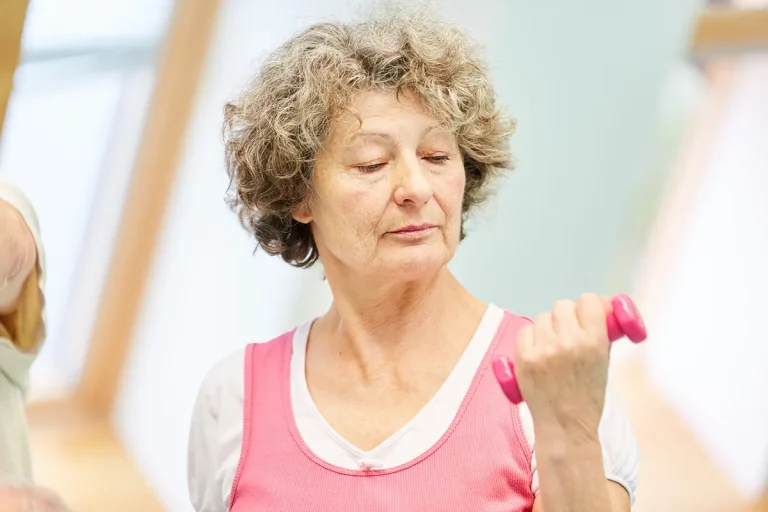 Femme senior pratiquant la musculation douce avec haltères à Toulouse